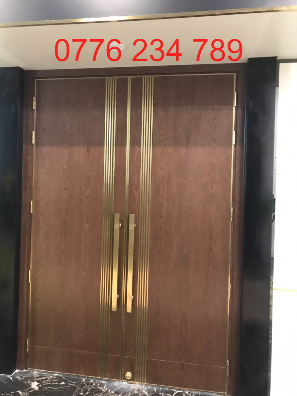 Trang trí tường và thang máy bằng nẹp inox vàng gương tại CityLand Cửa gỗ viền inox vàng